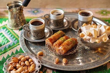 拜拉姆传统的阿拉伯甜甜点肉汁 加一杯咖啡土豆咖啡盘子小吃咖啡杯坚果蛋糕火鸡食物托盘烹饪桌子背景