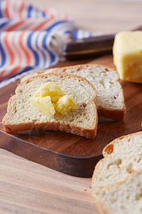 切片黄油和切碎板上的全餐面包乡村木板粮食食物烹饪脂肪黄色奶制品牛奶棕色背景图片