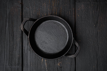 黑色烹饪锅 带有文字或食物的复制空间 带有文字或食物的复制空间 顶视图平躺 黑色木桌背景背景图片