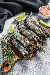 海虎新鲜的老虎虾 有香料和草药的虾 在切削板上 灰色背景甲壳黑虎动物贝类食物海鲜国王背景