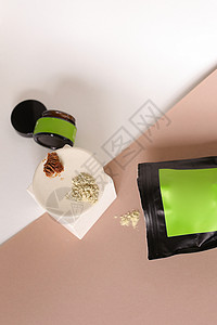 黑豆包和装有化妆品的罐子 以及板上粘土粉品牌的绿色空间背景图片