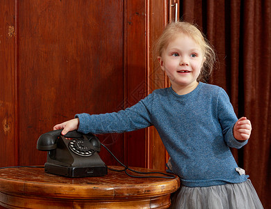 女孩们在老电话响起孩子技术时尚固定电话顾客商业女孩呼唤白色古董背景图片
