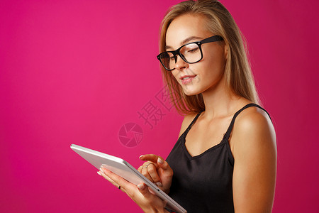 戴眼镜的年轻美女使用数字平板电脑金发快乐长发电子背景图片