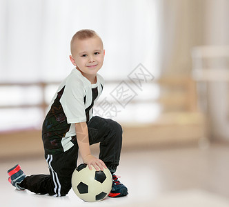 那个小男孩手里拿着球的小男孩游戏青年孩子幸福乐趣足球运动男性童年活动背景图片
