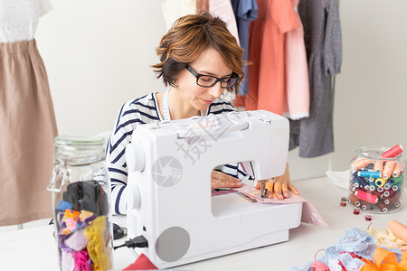 服装设计师 女裁缝 人物概念  服装设计师在她的工作室工作商务成人桌子纺织品缝纫服务女装人士裁缝手工企业家高清图片素材