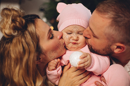 家长亲吻粉红色的女婴背景图片