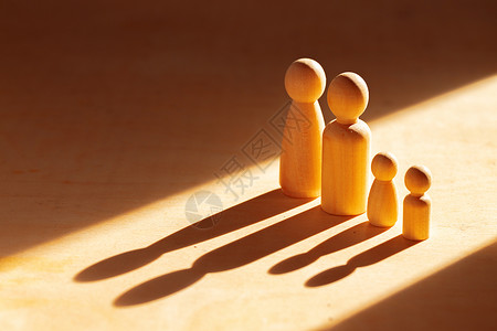 木桌上阳光下的四个木偶背景图片
