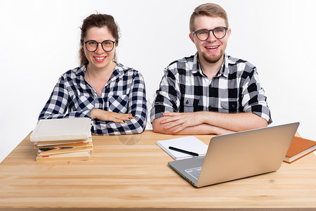 人与教育概念两名身着格格衬衫的学生坐在一张桌子上喜悦眼镜成人极客快乐男性享受斗争电脑男人背景图片