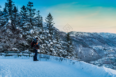 拍摄冬季风景照片的摄影记者高清图片