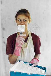 室内装饰房装修中涂刷油漆的女画家刷子工人成人家具女性画笔房子绘画女孩头巾背景图片