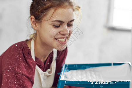 开心的女士在室内装修房里画一个房间工艺检查家具工人头巾艺术家维修装修画家画笔背景图片
