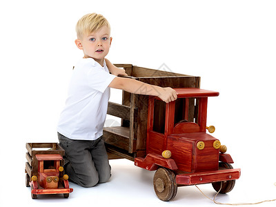 小男孩在玩木制汽车车轮喜悦运输车辆家庭玩具男性幸福男生活动背景图片