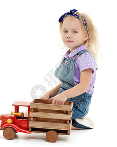 小女孩在玩木制汽车女孩苗圃学习地面游戏乐趣窗户车辆建筑火车背景图片