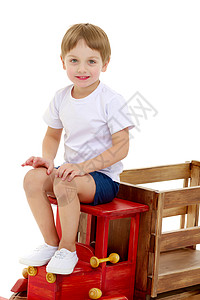 小男孩在玩木制汽车房间家庭教育乐趣婴儿学习游戏车轮地面闲暇背景图片