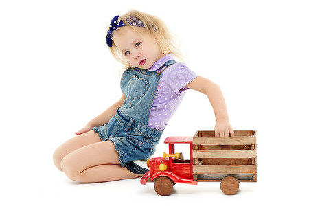 小女孩在玩木制汽车幼儿园女孩闲暇姐姐火车运输建筑地面窗户车辆背景图片
