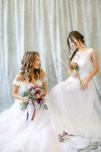 两位新娘坐在摄影棚 带鲜花背景图片