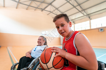 男孩坐在轮椅上 准备在大竞技场的篮球赛开始 有选择地集中关注人士游戏篮子残障训练男人椅子一体化机动性卫生背景图片