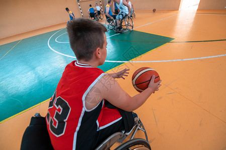 男孩坐在轮椅上 准备在大竞技场的篮球赛开始 有选择地集中关注车轮机动性残障竞赛康复男生篮球人士游戏运动背景图片