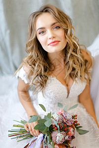 金发新娘 盛满鲜花束 在摄影棚坐着背景图片