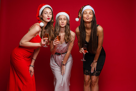 三个快乐的美女朋友 穿着漂亮的裙子 庆祝新年 欢喜共庆成人派对女性朋友帽子冒充乐趣喜悦白色衣服背景