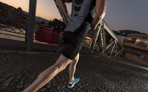 晚上跑步在城中穿过桥的男子慢跑运动装运动员短裤赛跑者力量城市男人活动慢跑者动机背景