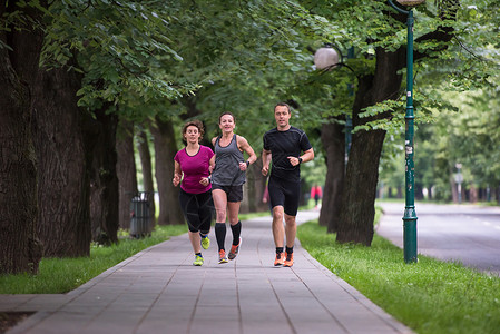 早上训练赛跑队街道公园成人行动培训师运动装运动员健康赛跑者微笑背景