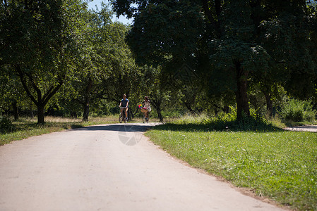 斯瓦族骑士具有自然骑自行车的多种族年轻夫妇朋友们骑术乐趣男性男人天空活动成人森林女性背景