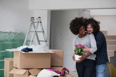进入新家园的多民族夫妇包装纸板夫妻公寓丈夫搬迁女性女士男人盒子背景图片