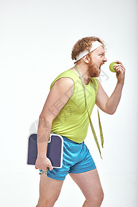 红头发 胡胡子 大胖子 拿着苹果和秤运动装重量身体乐趣男性男人运动健身房减肥管状背景图片