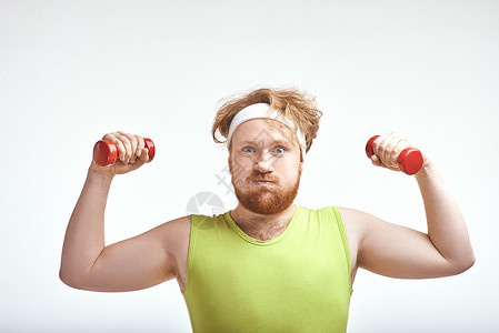 红发 胡胡子 大胖子抓着那些哑铃重量损失饮食身体健身房管状运动装运动肥胖手套背景图片