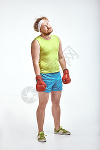 身穿运动服和红色拳击手套的红发 胡子 大胖子男子身体男人运动装动机饮食男性运动乐趣重量健身房背景图片