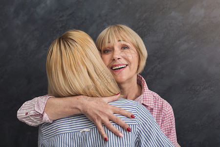 老母亲素材快乐的成年母亲和女儿拥抱灰色背景女性会议房间亲戚们喜悦中年家庭客人时间幸福背景