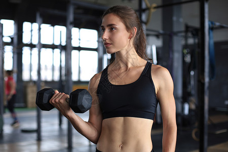 肌肉健壮的女人在健身房锻炼肌肉健美重量组织运动员辅导比基尼运动训练火车中心背景图片