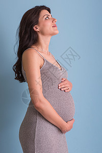 美丽的婴儿蓝色背景对孕妇的纵向照像快乐工作室怀孕成人女士母性身体女孩女性父母背景