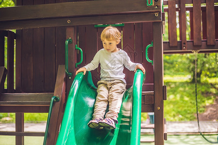 小男孩浇树可爱的小男孩在木木操场上玩耍冒险乐趣喜悦婴儿男生活动玩具学校运动铁路背景