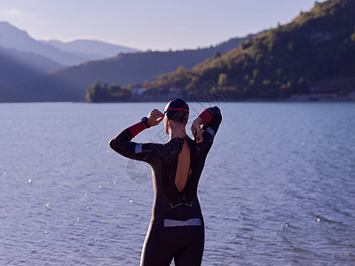 正在准备在湖上游泳训练的真正的三亚特隆运动员风镜活力竞赛钢铁侠潜水运动套装眼镜日落活动背景图片