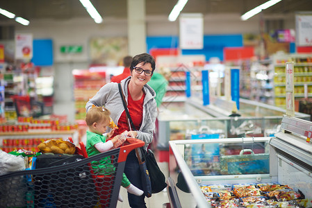 婴儿手推车购物时有婴儿的母亲成人蔬菜零售购物中心家庭妈妈女士杂货店父母顾客背景