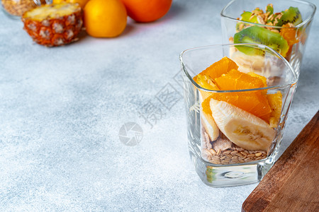 菠萝格木板上装有果片和燕麦糖浆的玻璃杯饮食桌子粮食麦片小吃产品食物种子谷物薄片背景