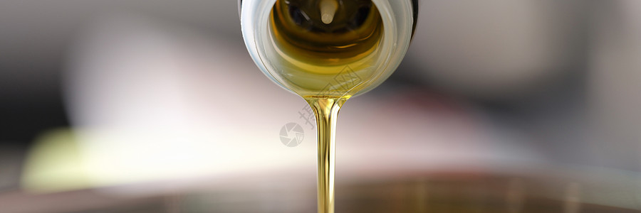干净的橄榄油从喷洒罐中倒入酱盆封口背景图片