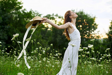 花潮素材穿白色衣服的妇女开着鲜花自由走新鲜空气女性金发晴天女孩自由阳光帽子草地微笑头发背景
