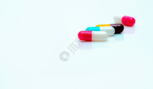 在白色背景的多色抗生素胶囊药片 选择性地关注粉色和白色胶囊药丸 抗生素耐药性 处方药 医药行业 抗菌药物背景图片