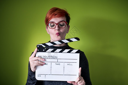 女性在绿色背景下拍摄电影拍手娱乐女士头发视频教育制片人粉笔木板钥匙运动背景