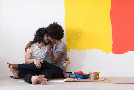 名族画多种族年轻夫妇在绘画后放轻松房间成人家庭夫妻男人刷子友谊男性喜悦公寓背景