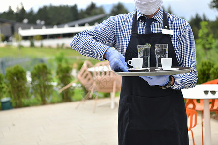 身戴医疗保护面罩的服务员在餐厅咖啡供应感染饮料手套流感工作服务柜台调酒师咖啡店商业背景图片
