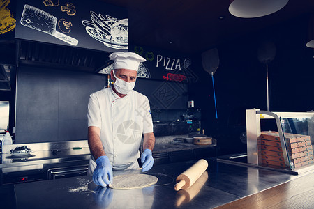 厨师用保护性冠状病毒面罩做披萨食物壁炉面包餐厅男人烤箱潮人职业面包师男性背景图片