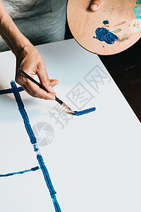 女高级老艺术家手的特写 拿着画笔 用蓝色油漆画画 五颜六色的情感油画 当代画家创作现代抽象美术作品教育学校班级刷子艺术女性女孩工背景图片