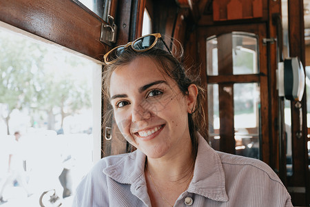 在波尔图的一辆旧火车里 戴墨镜的年轻女性在独立服装 旅行和新体验概念上对着镜头微笑背景