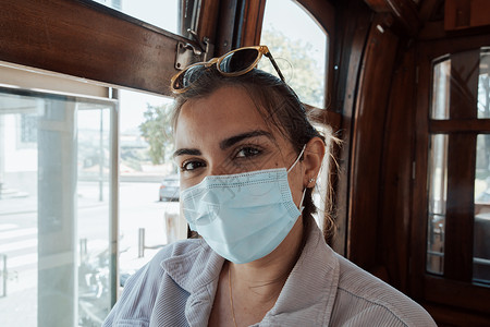 戴太阳眼镜的年轻女子和在门托老列车内面罩 对独立服装 旅行和新体验概念微笑到摄影机背景
