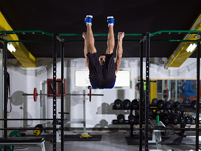 新疆拉条男人在水平条上拉起力量运动员锻炼运动运动装健身房健美重量俱乐部训练背景