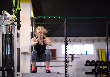 女职工在健身房里跳中心耐力奉献精神盒子力量健美活力成人跳跃背景
